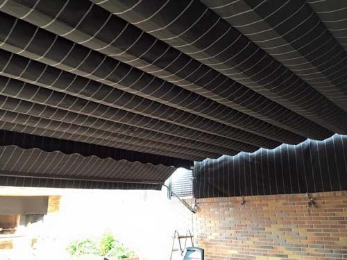 Un toldo negro cuelga del techo de un edificio.