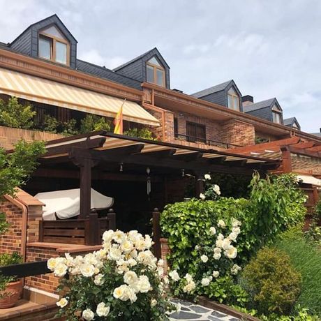 Una hilera de casas con flores delante de ellas.