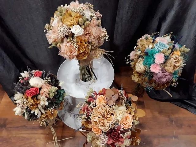Tres ramos de flores están sobre una mesa.