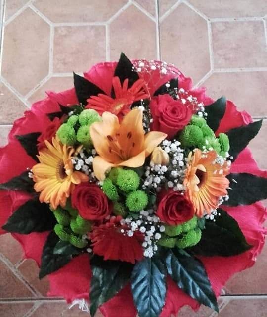 Un ramo de flores está sobre un suelo de baldosas.