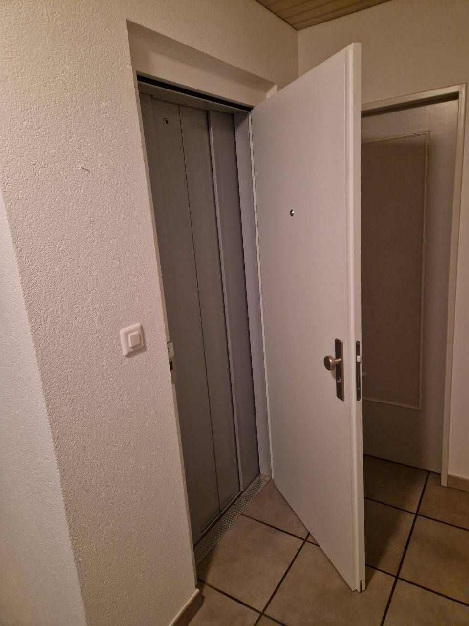 Moderner Büroempfangsbereich mit hellgrünem und weissem Schreibtisch und Glastür.