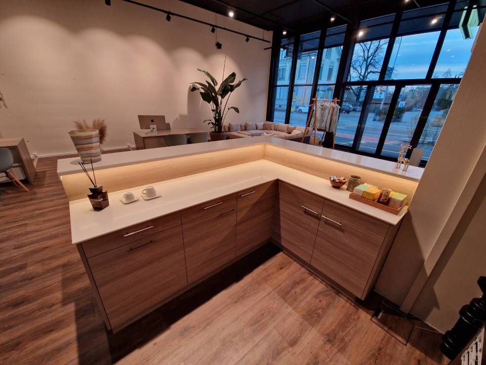 Leeres Zimmer mit blauer Wand, weissem Vorhang, Vase mit Zweigen und Holzboden.