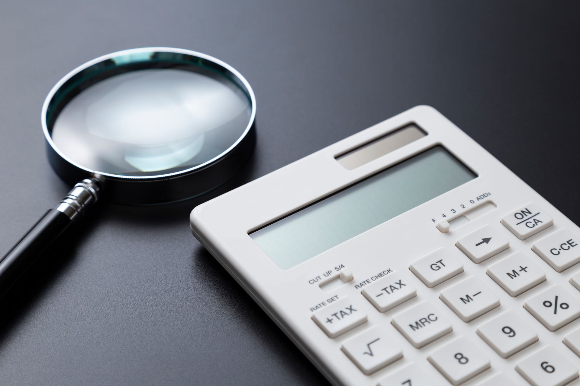 Calculatrice et loupe sur un bureau
