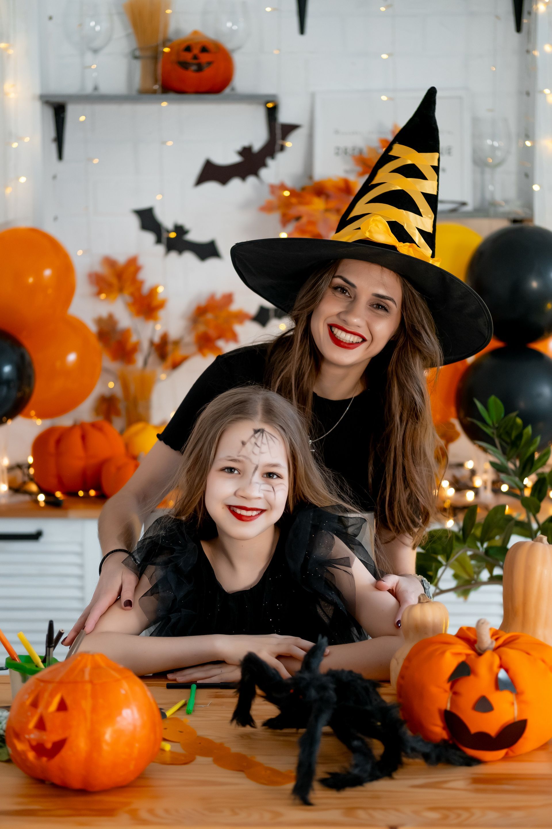 Dwie kobiety pozują przy stole z okazji Halloween,