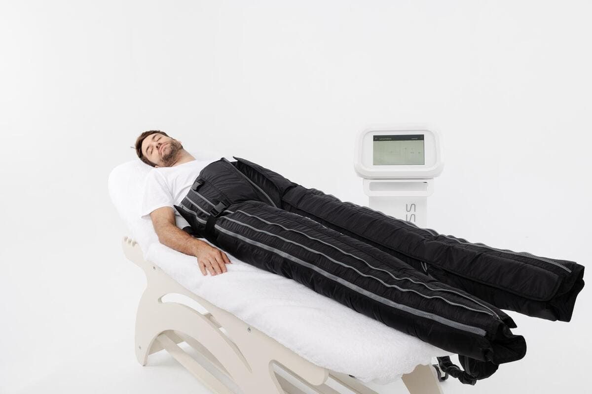 Mujer realizando un tratamiento de contorno corporal con un dispositivo manual en el abdomen de un cliente.