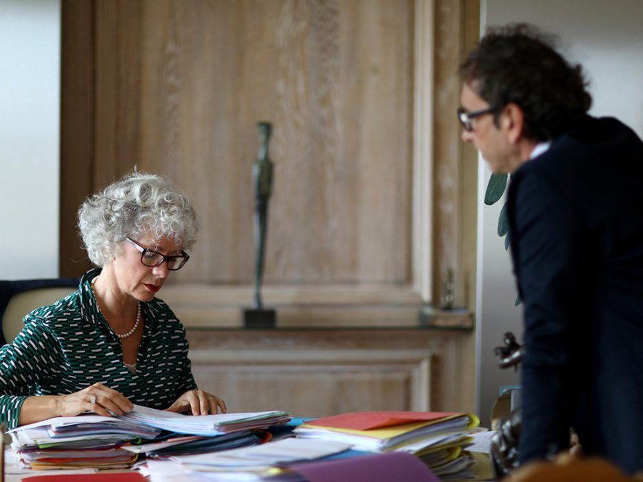 Une avocate assise regarde un autre avocat