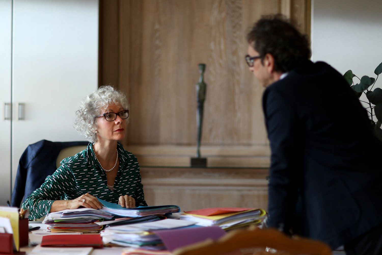 Une avocate assise regarde un autre avocat