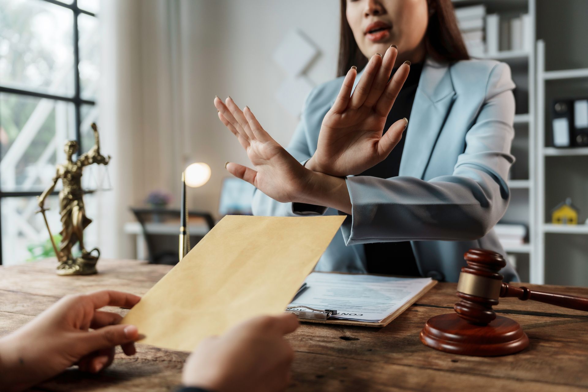 Une femme en tailleur refuse une enveloppe tendue
