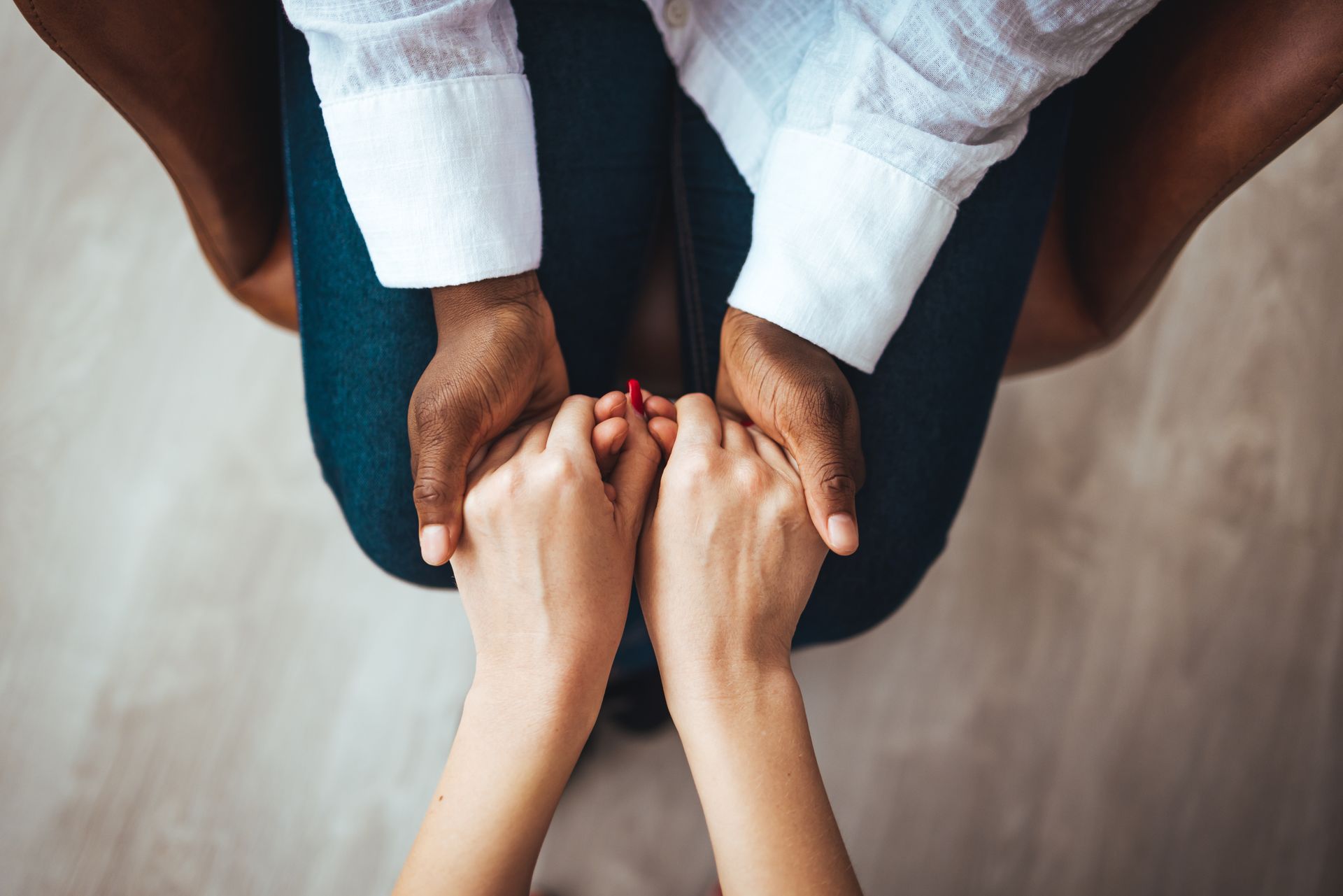 Une femme assise tient les mains d'une autre femme