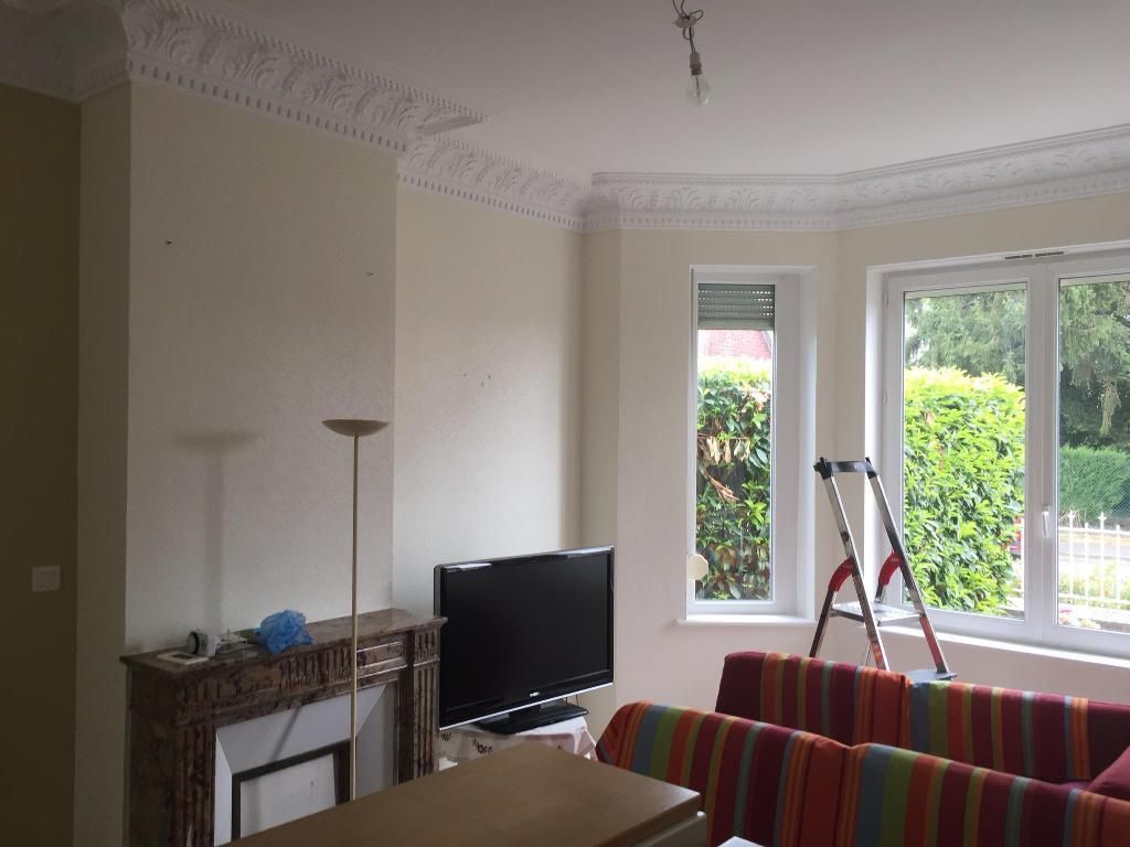 Salon avec cheminée, téléviseur et canapé à rayures multicolores.