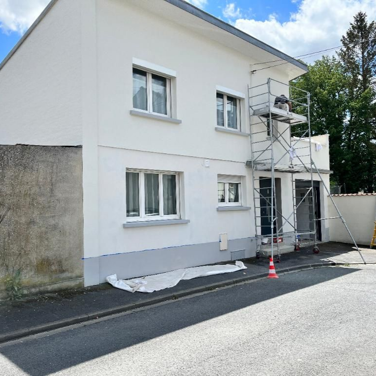 Maison blanche avec échafaudages pour rénovations.