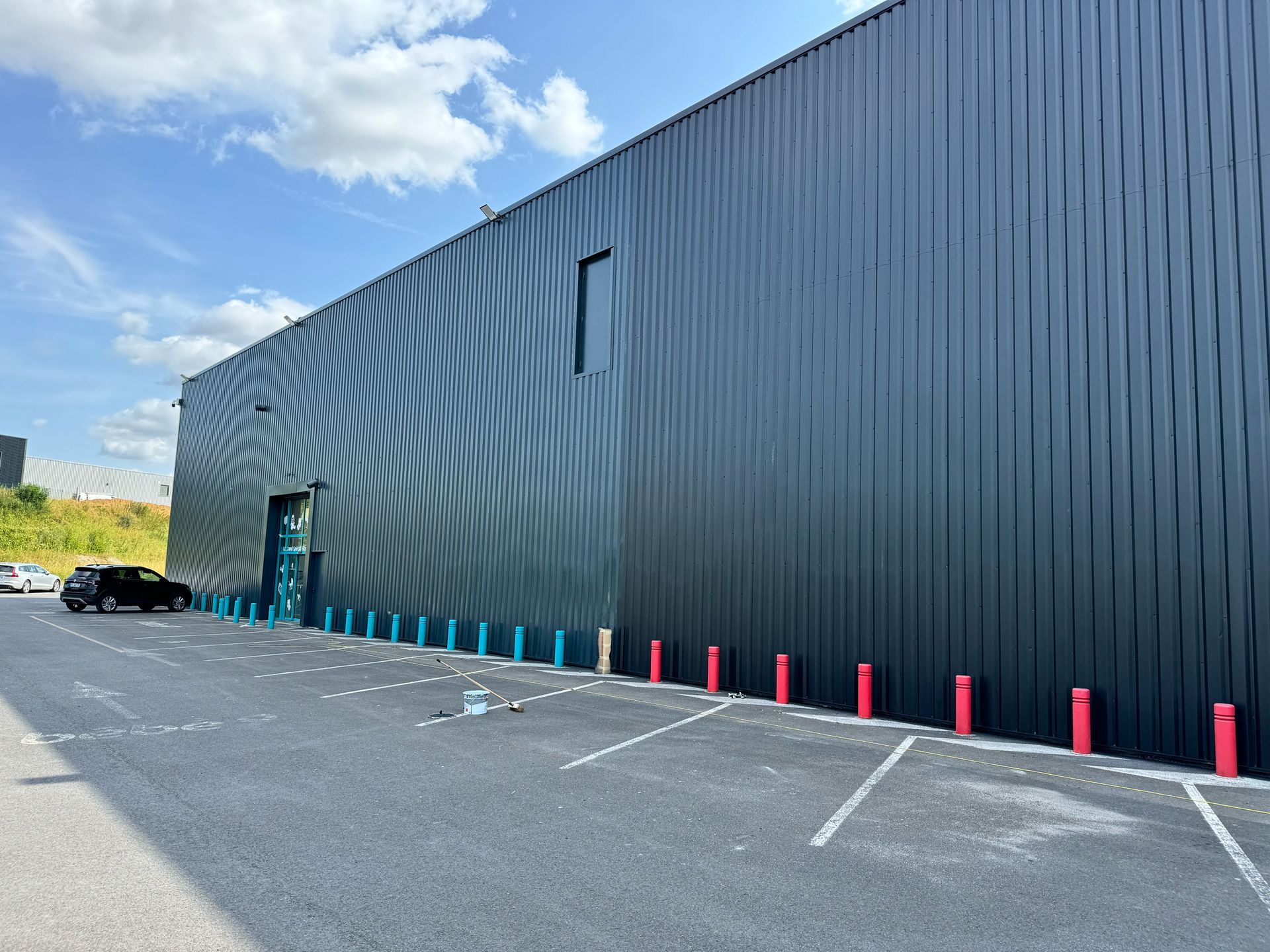 Extérieur d'un bâtiment commercial gris foncé avec bardage métallique.