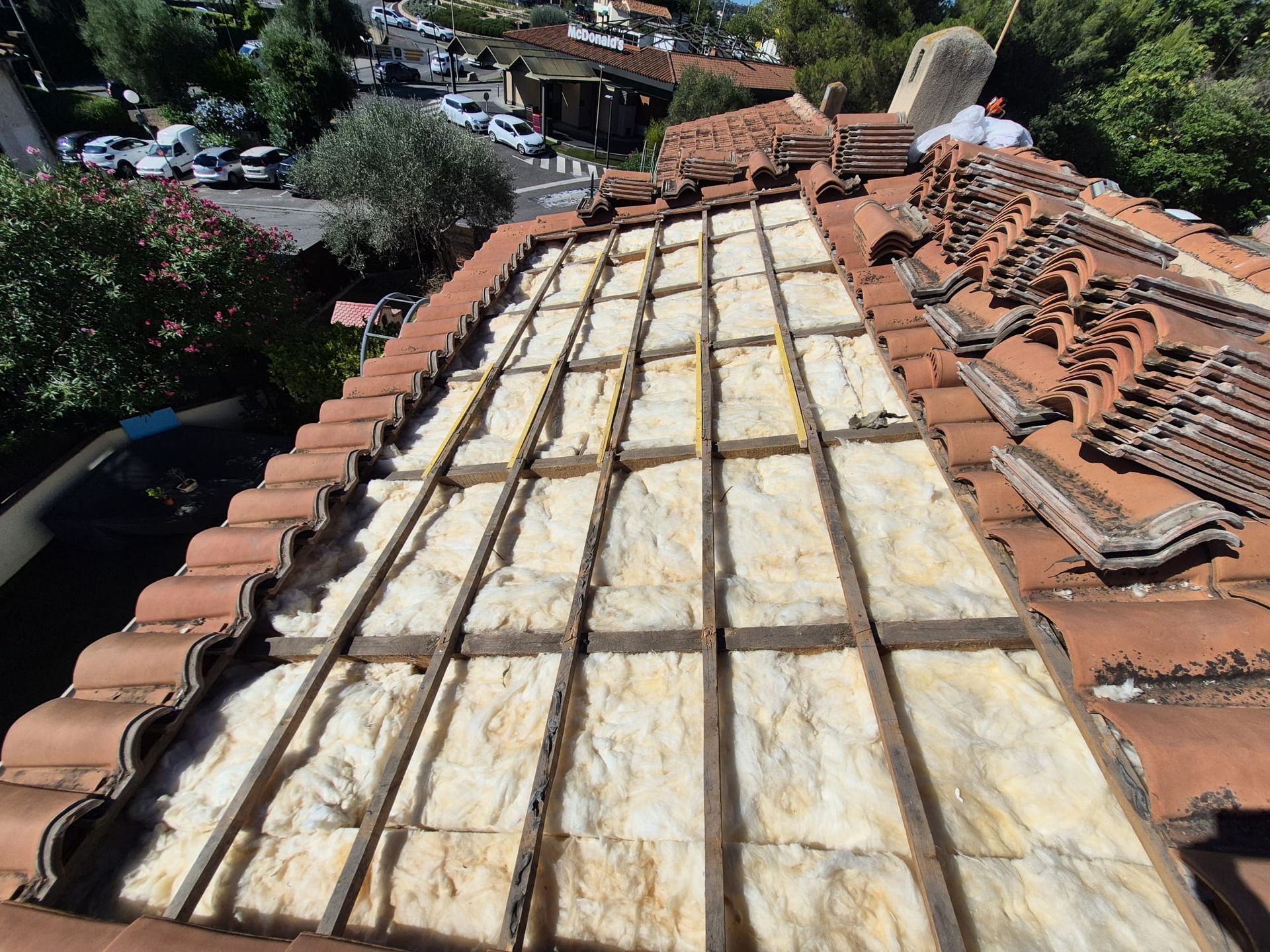 Un bâtiment en construction avec des échafaudages autour et un ciel bleu en arrière-plan.