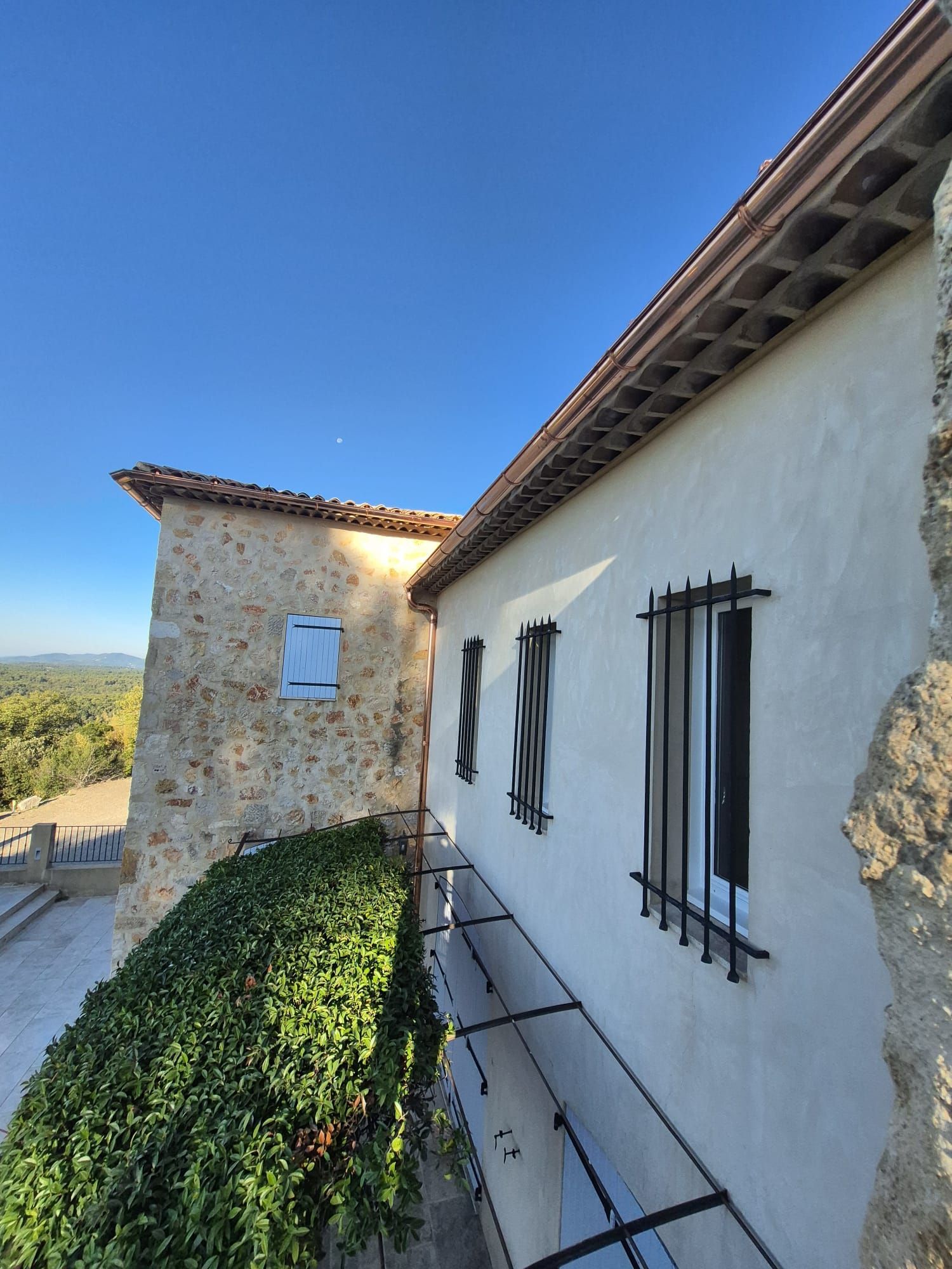 Un gros plan d'un toit en métal avec un toit en arrière-plan.