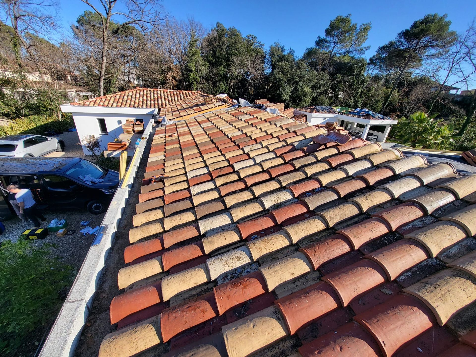 Toit de tuiles en terre cuite sur un bâtiment sous un ciel bleu azur.