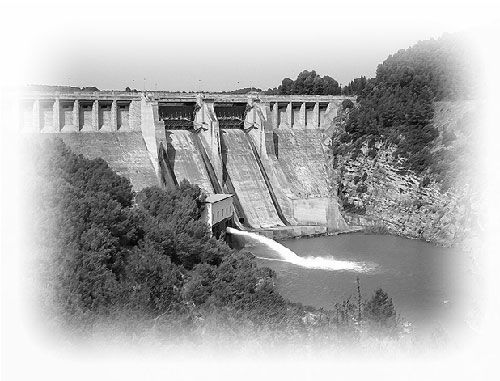 Una fotografía en blanco y negro de una presa de la que sale agua.