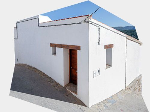 Una casa blanca con puerta y ventanas de madera
