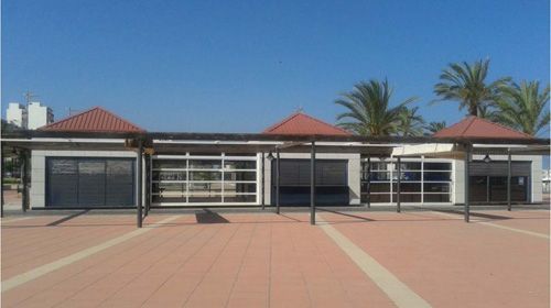 Un edificio con techo rojo y una pasarela cubierta