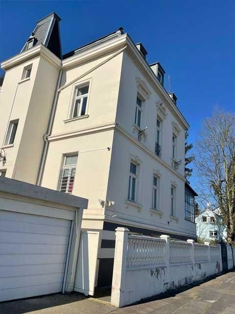 Ein großes weißes Gebäude mit einer Garage davor