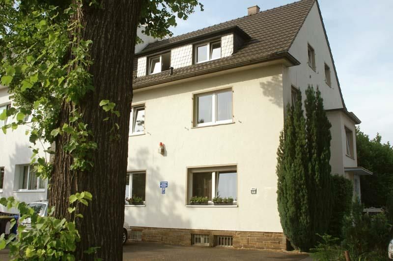 Ein weißes Haus mit einem Baum davor