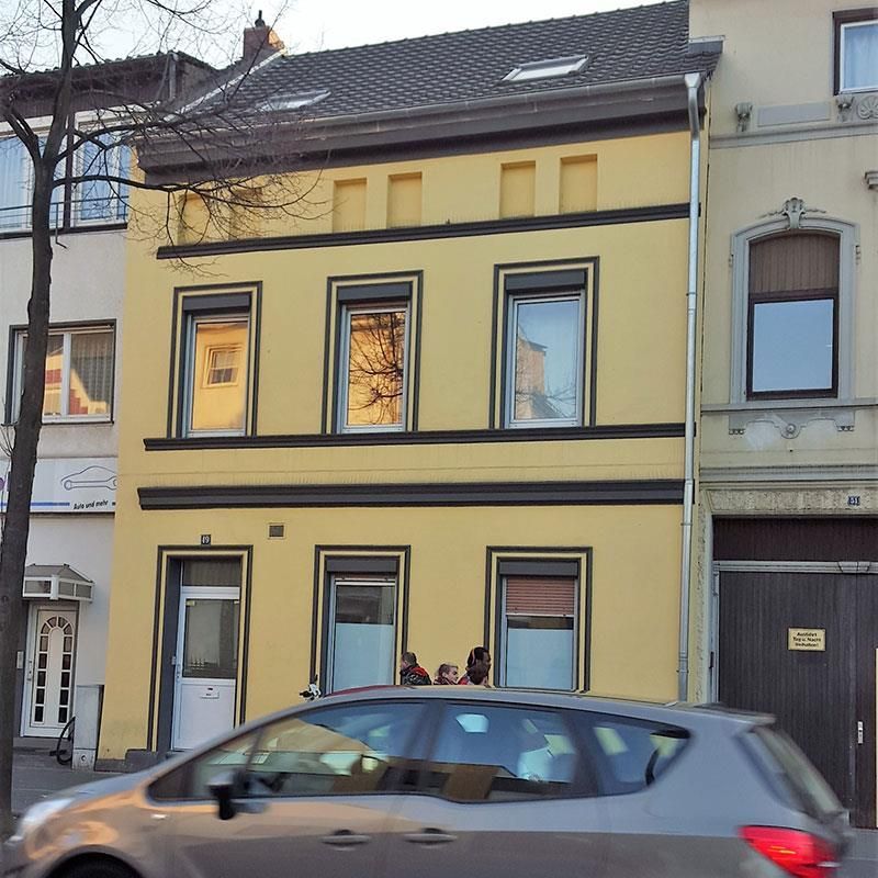 Ein Auto ist vor einem gelben Gebäude geparkt