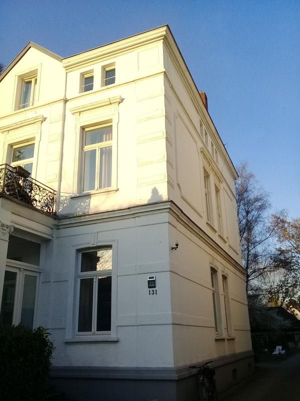 Ein großes weißes Gebäude mit der Nummer 130 an der Seite