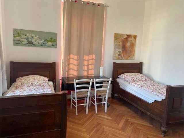 Ein Schlafzimmer mit zwei Betten, einem Tisch und Stühlen.