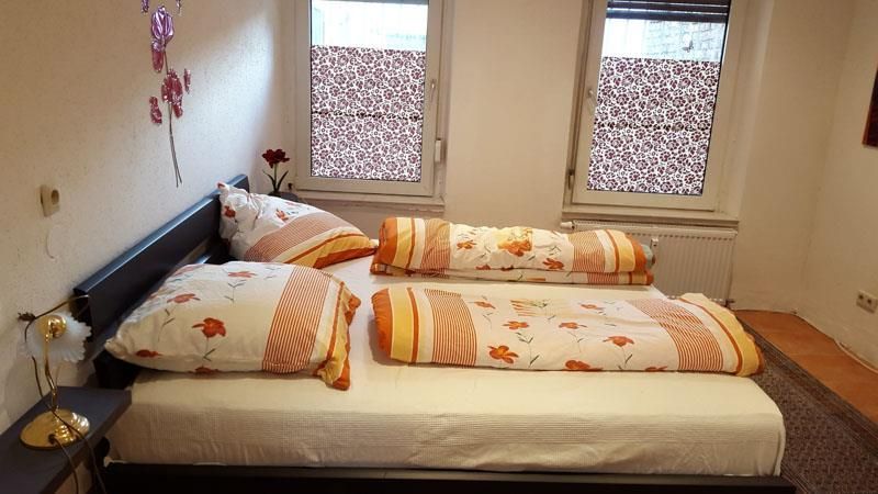 Ein Schlafzimmer mit zwei Betten und zwei Fenstern.