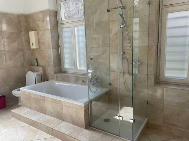 Ein Badezimmer mit Badewanne, WC, Dusche und Fenster.