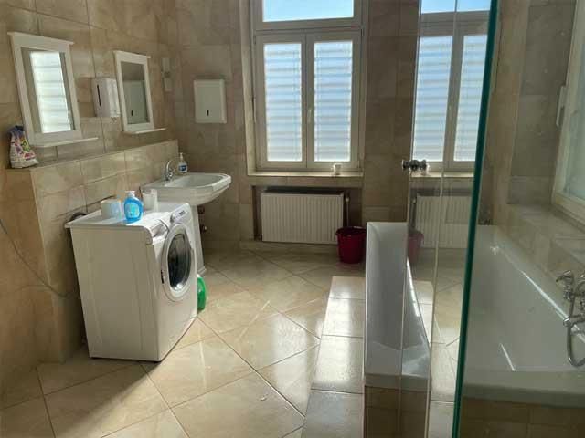 Ein Badezimmer mit Waschmaschine, Waschbecken und Badewanne.