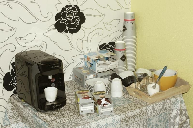 Eine Kaffeemaschine steht auf einem Tisch neben einem Tablett mit Tassen