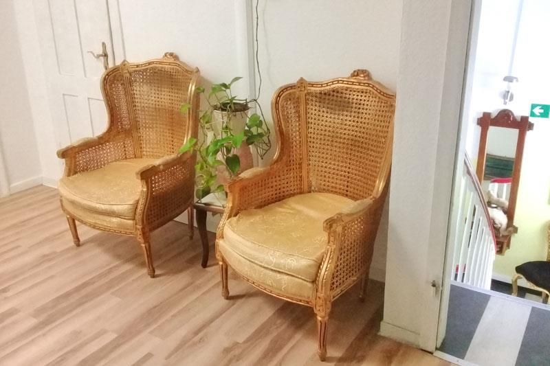 Zwei Korbstühle stehen nebeneinander in einem Raum.