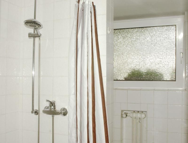 Ein Badezimmer mit Dusche und Fenster