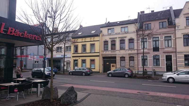 Eine Reihe von Gebäuden, vor denen Autos geparkt sind.