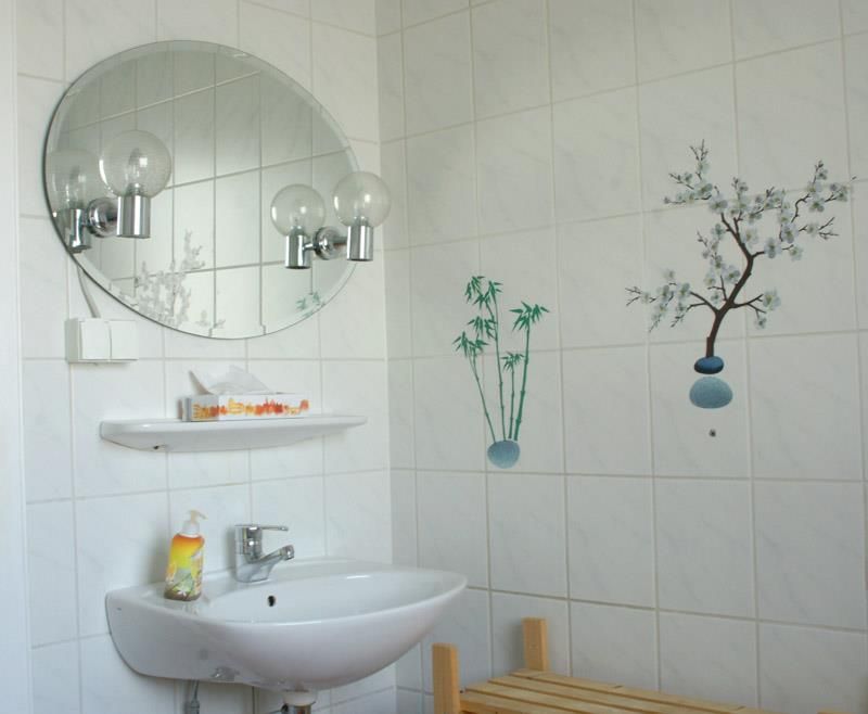 Ein Badezimmer mit Waschbecken und rundem Spiegel