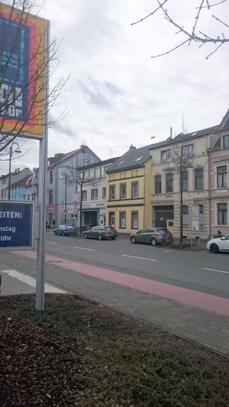 Eine Reihe von Gebäuden steht an einer Straßenseite.