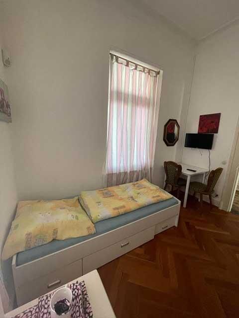 In der Mitte des Zimmers steht ein Einzelbett.