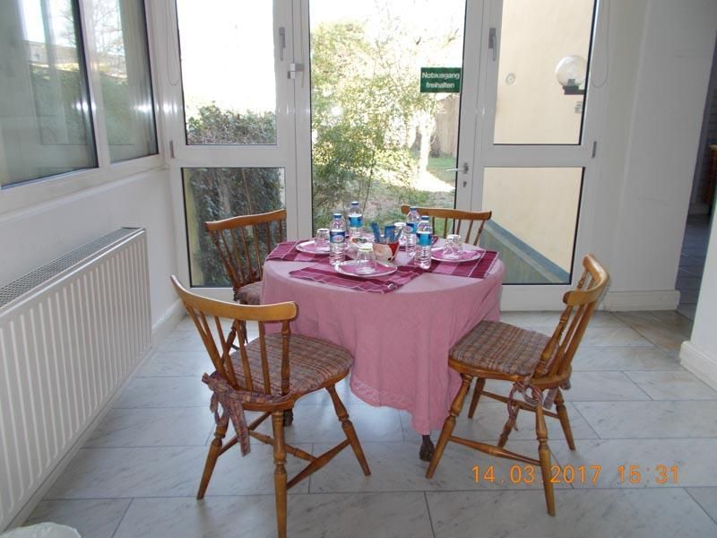 Ein Tisch mit rosa Tischdecke und vier Stühlen