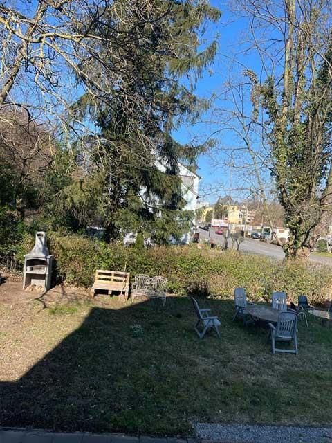 Ein Hinterhof mit Tisch, Stühlen und Grill.