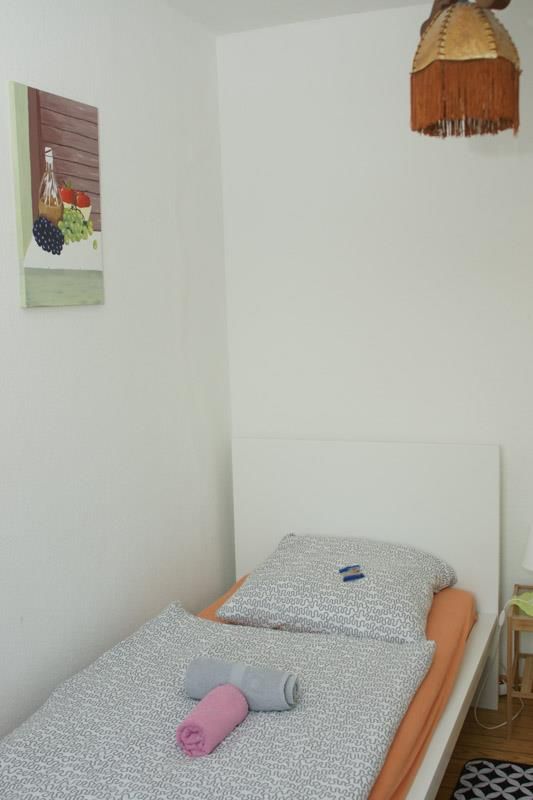 Ein Schlafzimmer mit einem Einzelbett und einem Gemälde an der Wand