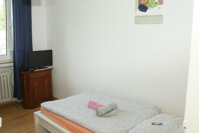 Ein Schlafzimmer mit einem Bett und einem Fernseher an der Wand