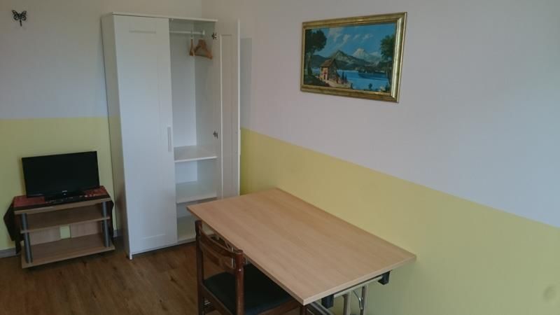 An der Wand über dem Tisch im Zimmer hängt ein Bild.