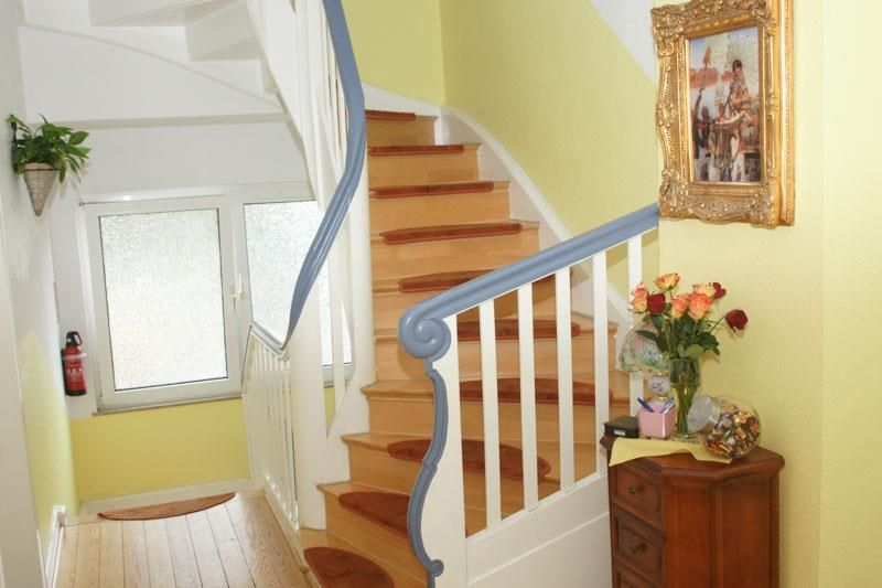 Ein Flur mit Treppe und einem Bild an der Wand