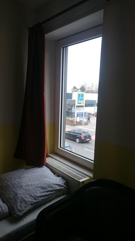 Ein Schlafzimmer mit einem Bett und einem Fenster mit Blick auf eine Straße.