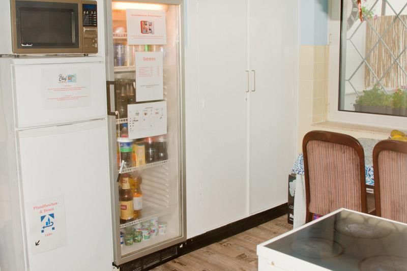 Eine Küche mit Kühlschrank, Mikrowelle und Tisch.