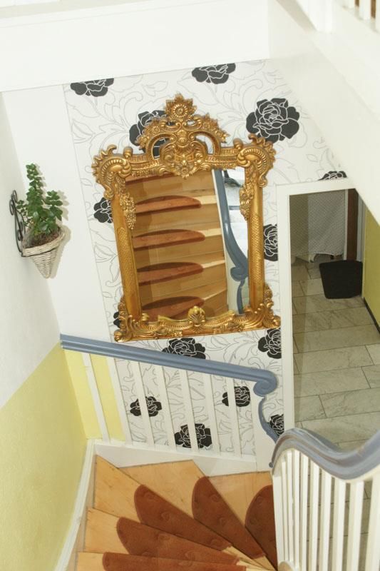 Eine Wendeltreppe mit einem goldenen Spiegel an der Wand