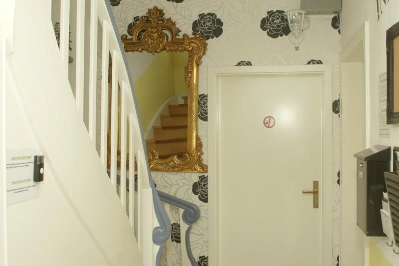 Ein Flur mit Treppe und einem Spiegel an der Wand
