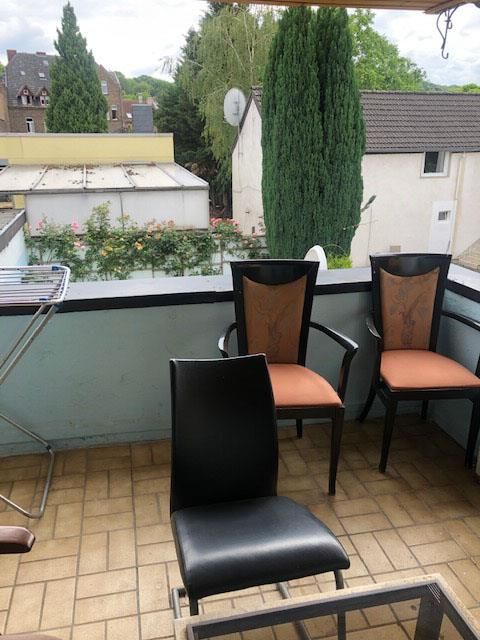 Ein Balkon mit zwei Stühlen und einem Couchtisch