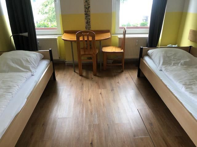 Ein Schlafzimmer mit zwei Betten und einem Tisch und Stuhl