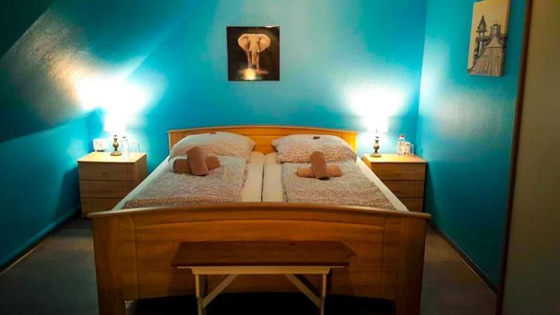 An der Wand über dem Bett hängt ein Bild von einem Elefanten.